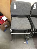 Front view of one gray cushioned metal frame chair showing the seat and backrest.