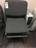 Four gray fabric cushioned chairs stacked, showing chrome tubular metal frame and fabric upholstery, with dimensions approx 18x22x31 inches each.