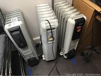 Three space heaters: Kenwood EW7307K radiator heater on the left, Lakewood 7096 radiator heater in the middle, and DeLonghi 3017 space heater on right corner, showing front and side views.