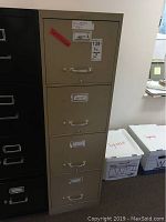 Tan 4-drawer metal file cabinet with metal handles and label holders shown alongside adjacent filing units.