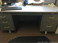 Gray office desk with keyboard, phone on top, showing five drawers and space underneath