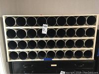 Rack showing entire multi-row tubular blueprint storage with 36 black tubes and labeled slots