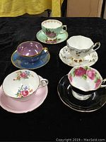 Overview of the 5 vintage bone china teacups and saucers with florals and gold accents