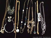 Photo of 10 assorted costume jewelry necklaces showing various chain styles, bead designs, and a detached pendant.