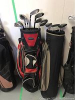 Front view of two golf bags side by side: red Founders Club bag with 9 clubs and black bag with 4 clubs.