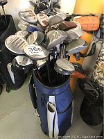 Blue Ram golf bag filled with a large assortment of golf clubs viewed from one angle showing club heads and shafts.