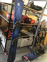 Full view of Rossignol blue snowboard standing upright, showing bindings and wear on the board.