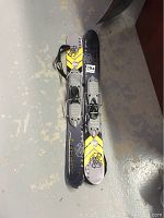 Pair of Firefly RX69 snowblades placed side by side on floor showing full length and bindings.