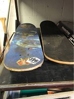 Blue skateboard deck showing faded graphics and wear on edges.