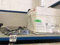 Four golf clubs laid out in front of a cardboard box with club covers inside, showing condition and packaging.