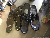 Pair of Element 9x30 green frame snowshoes and Thunderbay black plastic snowshoes lying on floor