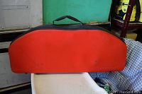 Closed black and orange carrying bag for croquet set, showing its shape and handle