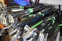 Golf clubs bundled together viewed from the top showing heads and shafts with tape securing them.