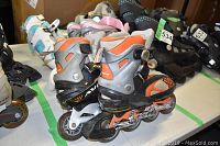 Two pairs of youth adjustable rollerblades positioned side by side showing condition and wear.