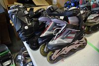 Two pairs of men's rollerblades on a table, black pair behind Airwalk Free Spirit pair, showing general wear