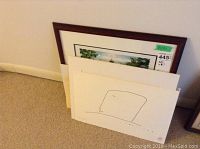 Full view of framed and unframed prints stacked against wall, showing sizes and matting of prints.