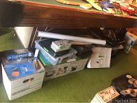 Overall view of multiple art supply boxes and Cricut machine box under pool table
