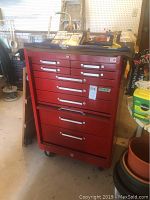 Front view of red metal tool chest on wheels