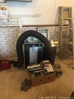 Photo showing Commercial Cool portable air conditioner with black flexible exhaust hose and box of tools and chain in foreground