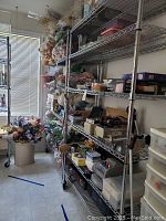 Metal wire rack placed by a wall next to window with flowers stored around but rack empty.
