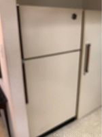 Closed view of the refrigerator showing the cream-colored exterior with metal handle.