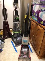 View of Dirt Devil Easy Steamer steam cleaner and Hoover SpinScrub carpet cleaner side by side showing size and design.