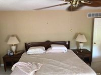 Photo showing two wooden night stands on each side of a bed with lamps not included.