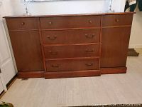 Front view of wooden buffet with four drawers and two side cabinets, showing overall condition and finish.
