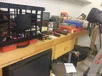 Wide view showing toolbox, handtools, clamps, and hardware on workbench