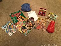 Full view of all items including comic books, marbles display box, leather pouch, and cloth bag.
