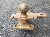 Close up image of a 2 5/16 inch trailer hitch ball mount showing rust and mounting holes.