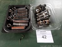 Photo of two trays with various chrome sockets of different sizes, including some deep sockets and adapters.
