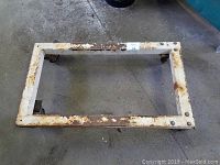 Top view of rectangular metal moving cart showing rust and wear on frame and casters.
