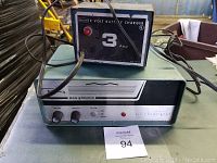Sears 12 Volt 3 Amp battery charger mounted on top of Regency Monitoradio unit. Front panels showing controls and indicators.