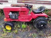 Side view showing red riding mower body, yellow front wheel, and black rear wheel with detailed tread.