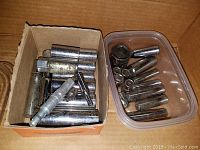 Two containers filled with assorted metal sockets of various sizes and lengths.
