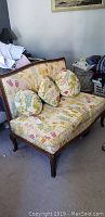 Vintage embroidered upholstered settee with floral patterned fabric and cabriole legs.