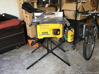 Frontal view of DeWalt table saw mounted on folding stand in garage.