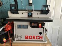 Front view of router table and cabinet showing Bosch logo and power switch