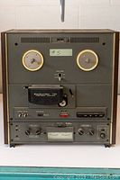 Front view of vintage Dokorder 7100 reel to reel tape recorder showing the two tape spools, control panel with knobs, switches and meters.