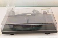 Side view of turntable with dust cover closed and power cable coiled behind