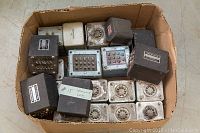 Box of approximately 18 transformers showing various black Hammond units and metal can types