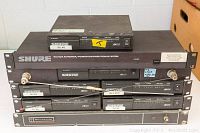 Photo showing rack-mounted Shure wireless microphone receivers and WA404 antenna/power distribution system with frequency labels and antenna cable.