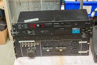 Four stacked rack-mountable audio units showing front panels and connections with light wear.