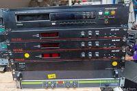 Stack of AV equipment including Marantz CD player on top, three Finline SM-550 video professional modulators below, Sony antenna divider, and Ecleree active filter at bottom. Shows rack ears and front panels with buttons and displays.