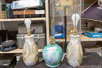 Two taller hand-painted pottery lamps approximately 21.5 inches tall, and one shorter turquoise hand-painted pottery lamp approximately 16 inches tall, all without lampshades.