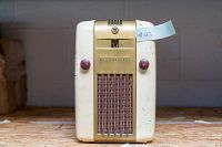 Front view of vintage Westinghouse tube radio showing brand name, logo, gold-tone grille, and maroon knobs