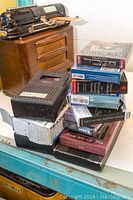 Photo of a stack of books on CDs and a vintage wooden Bigston cassette deck in the background