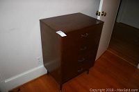 Photo of the dresser from the front and left side, showing 4 drawers and overall condition.