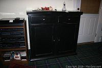Front view of the black wooden cabinet showing two drawers and double doors.